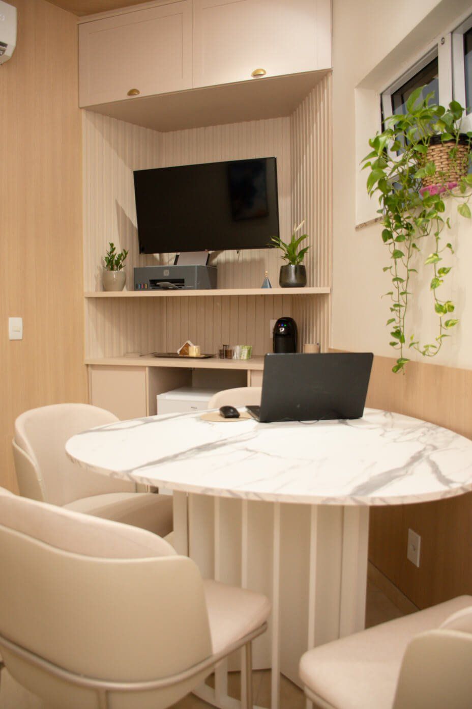 imagem de uma sala do consultorio com mesa e cadeiras, computador e televis&atilde;o